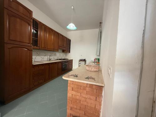 a kitchen with wooden cabinets and a counter top at Casa Vacanze " 'A Chiazza" in Marina di Casalvelino