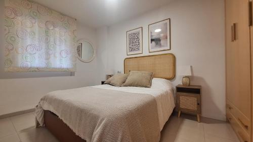 ein Schlafzimmer mit einem großen Bett und zwei Fenstern in der Unterkunft MISTRAL 2 Habitaciones in Oropesa del Mar