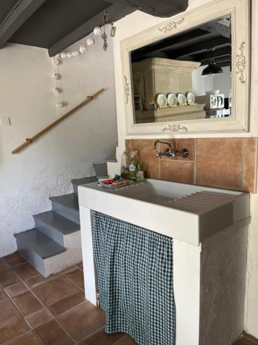 une cuisine avec un évier, un miroir et des escaliers dans l'établissement The Little House, à Saint-Simon-de-Bordes