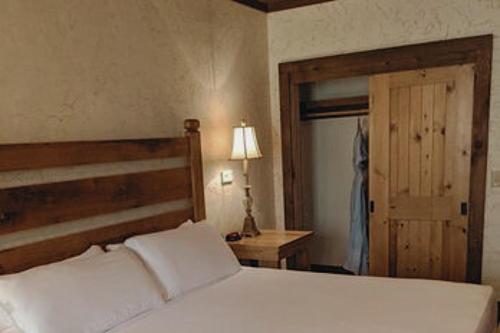 a bedroom with a white bed with a wooden headboard at Stonewater Cove in Shell Knob