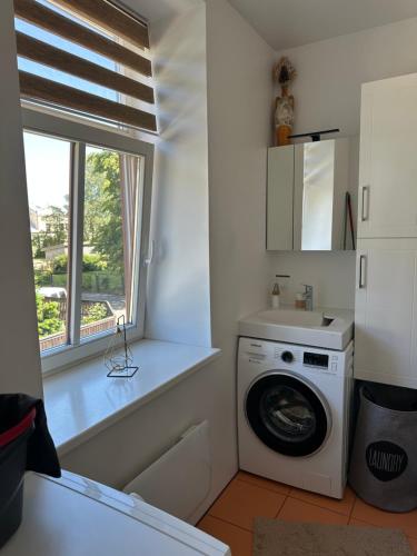 a laundry room with a washing machine and a window at Studija tipa dzīvoklis blakus jūrai in Liepāja