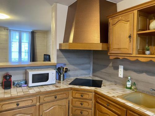 une cuisine avec un évier et un micro-ondes sur un comptoir dans l'établissement C3 Familiale Parking 2 chambres 4 lits 5 personnes WiFi, à Imphy