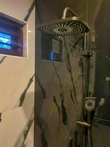 a shower in a bathroom with a glass wall at BOB Forest Stay in Batheri