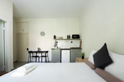 a bedroom with a white bed and a kitchen at Studio 91 By IsrApart in Ramat Gan