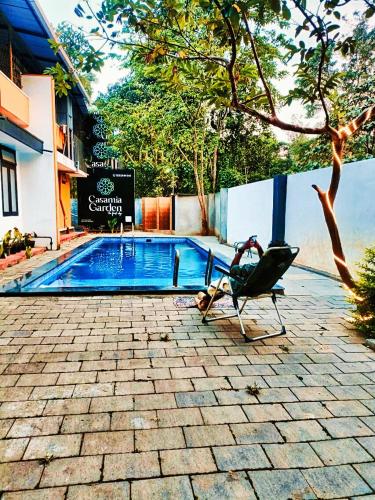 a chair sitting next to a swimming pool at BOB Forest Stay in Batheri