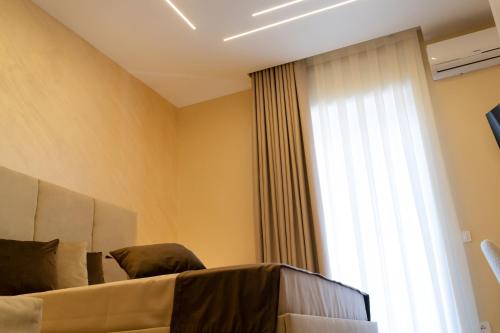 a bedroom with a bed and a large window at Partenope's House in Ercolano