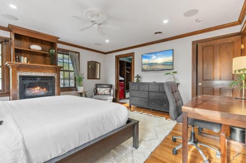 a bedroom with a bed and a desk and a fireplace at Linden Hills Haven in Edina
