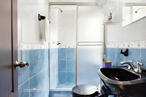 a bathroom with a shower and a sink and a toilet at Casa con huerto orgánico. in Subachoque