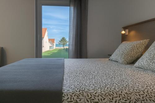 a bedroom with a bed and a large window at Pes Na Area Fisterra 01 in San Martín de Arriba