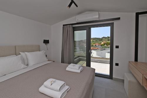 a bedroom with a bed with two towels on it at Agios Nikolaos Villas in Ayios Nikolaos Sithonia