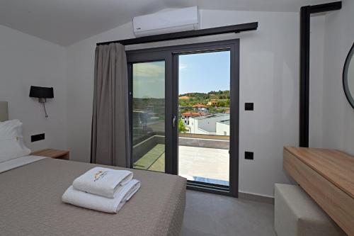 a bedroom with a bed and a large glass window at Agios Nikolaos Villas in Ayios Nikolaos Sithonia