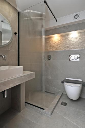 a bathroom with a shower and a toilet and a sink at Agios Nikolaos Villas in Ayios Nikolaos Sithonia