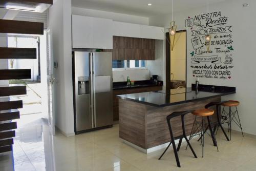 una cucina con frigorifero e bancone con sgabelli di Luxurious Country House a Pereira