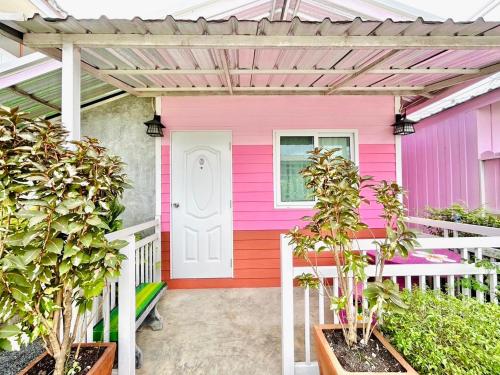 a pink house with plants in front of it at Home one love Ayutthaya bangalow zone in Phra Nakhon Si Ayutthaya