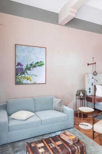 a living room with a blue couch and a table at Borgo Dei Conti Resort Relais & Chateaux in Monte Petriolo