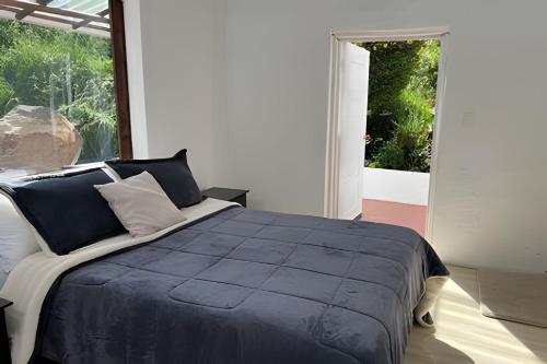 a bedroom with a large bed and a large window at La casa del cielo in Subachoque