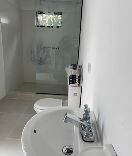 a white bathroom with a sink and a toilet at La casa del cielo in Subachoque