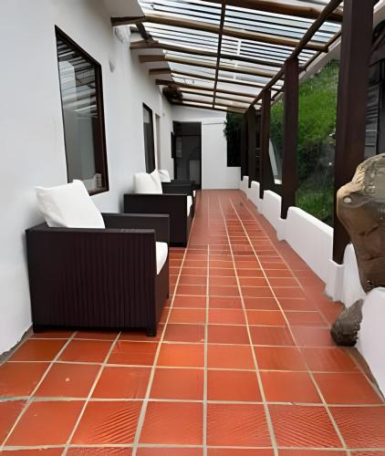 a room with couches and chairs on a tiled floor at La casa del cielo in Subachoque