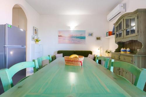 a kitchen with a green table and chairs at Sea View House on the Gulf of Asinara in Badesi