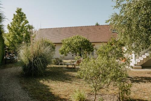 a house with a yard with bushes and trees at Logis Hôtel du Château in Tour-en-Sologne