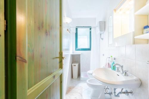 a bathroom with a sink and a toilet at Sea View House on the Gulf of Asinara in Badesi