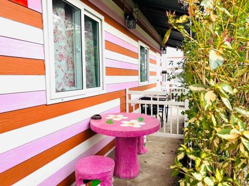 a pink table and two stools in front of a house at Pink house by Home one love in Phra Nakhon Si Ayutthaya