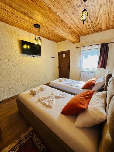 a room with two beds in a room with a ceiling at Guesthouse Gjoni Theth in Theth