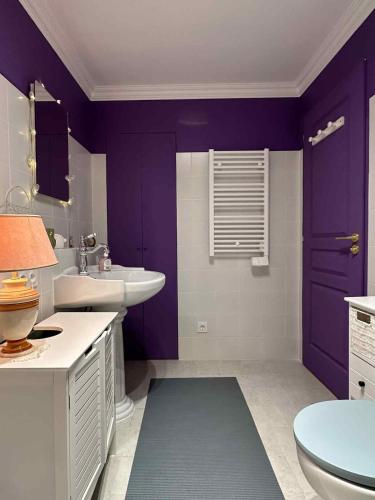 a purple bathroom with a sink and a toilet at Appartement cozy style Friends in Nîmes