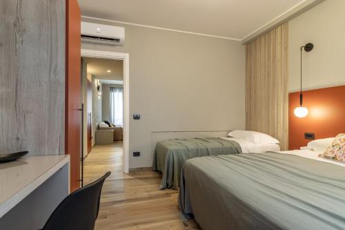 ラ・スペツィアにあるNOEMI chic rooms and apartmentsのベッド2台と椅子があるホテルの部屋
