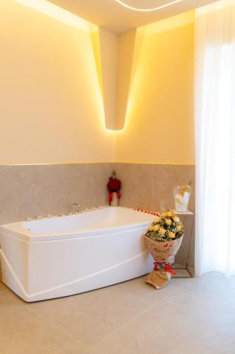 a white tub in a bathroom with a yellow wall at Partenope's House in Ercolano