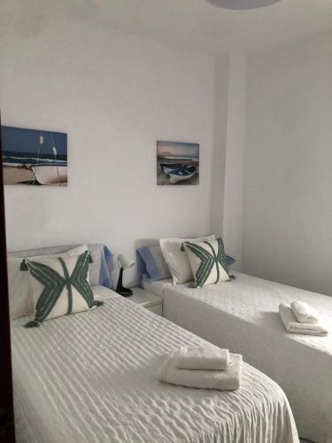 a room with two beds with towels on them at Apartamento Relax Centro in Sanlúcar de Barrameda