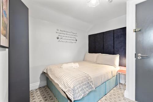 a small bedroom with a bed with a black headboard at 44 North in Londonderry County Borough