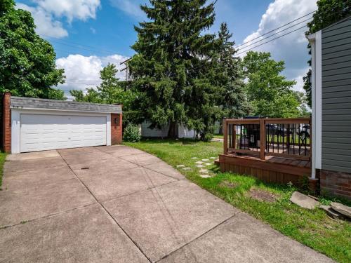 a driveway with a garage and a fence at Stylish Home - Game Room - Wet Bar - Sleeps 9 - Outdoor in South Euclid