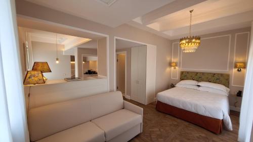a bedroom with a bed and a couch and a chandelier at Best Western Hotel Rivoli in Rome