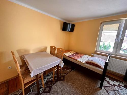 a room with a bed and a table and a window at Noclegi Fikusówka in Opole