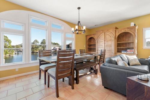 a dining room with a table and a couch at Inlet Palms in Kill Devil Hills