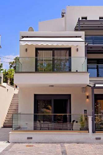 a large white house with a glass balcony at Agios Nikolaos Villas in Ayios Nikolaos Sithonia