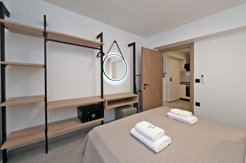 a bedroom with a bed with a mirror and towels at Agios Nikolaos Villas in Ayios Nikolaos Sithonia