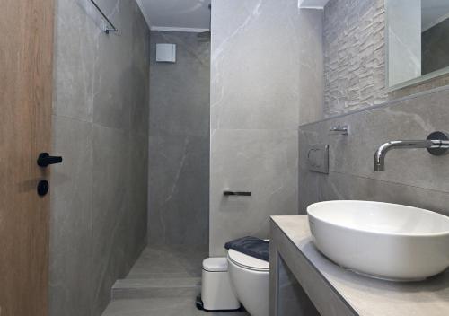 a bathroom with a white sink and a toilet at Agios Nikolaos Villas in Ayios Nikolaos Sithonia