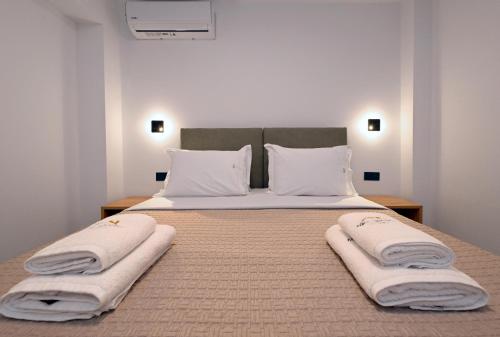 a bed with white blankets and pillows on it at Agios Nikolaos Villas in Ayios Nikolaos Sithonia