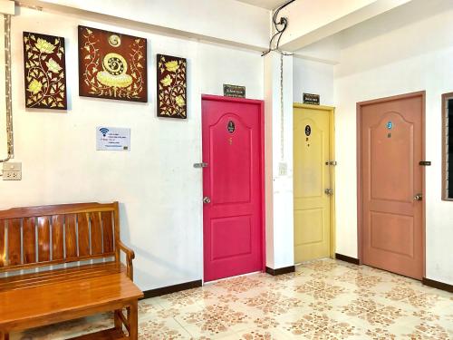 a room with three doors and a bench at Home One Love Ayutthaya GH in Phra Nakhon Si Ayutthaya