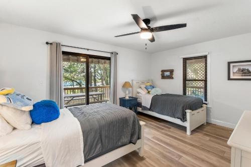 a bedroom with two beds and a ceiling fan at Inspect2Sea in Duck