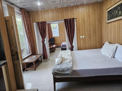 a bedroom with a large bed and a window at Maskan Guest House in Murree