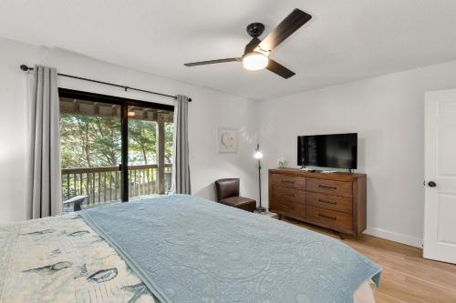 a bedroom with a bed and a ceiling fan at Inspect2Sea in Duck