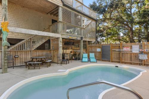 a large swimming pool with a deck and a table at Inspect2Sea in Duck