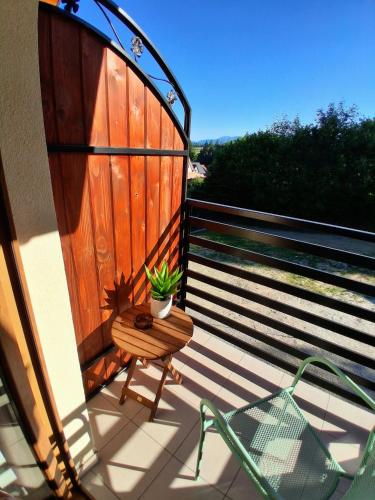 a balcony with a table and a chair and a plant at Apartamenty u Chlipały in Krośnica