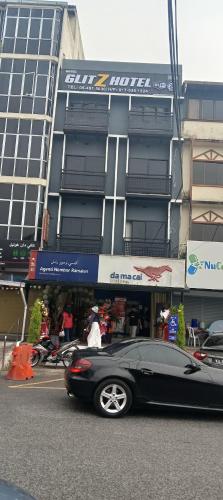a black car parked in front of a building at Glitz Hotel in Brinchang