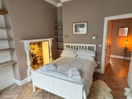 Un dormitorio con una cama y una chimenea. en Largs Sandringham Apartment, en Largs