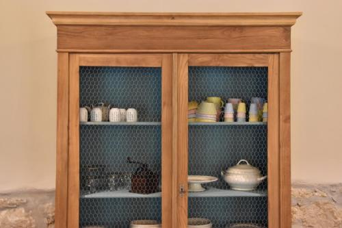 a wooden cabinet filled with dishes and bowls at La Vecchia Scuola in Stifone