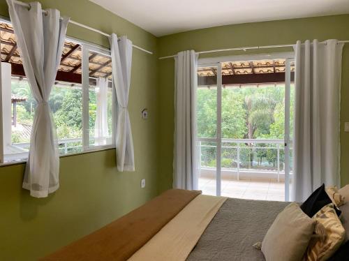 1 dormitorio con paredes verdes y 1 cama con ventana en Casa beira Rio, en Sana